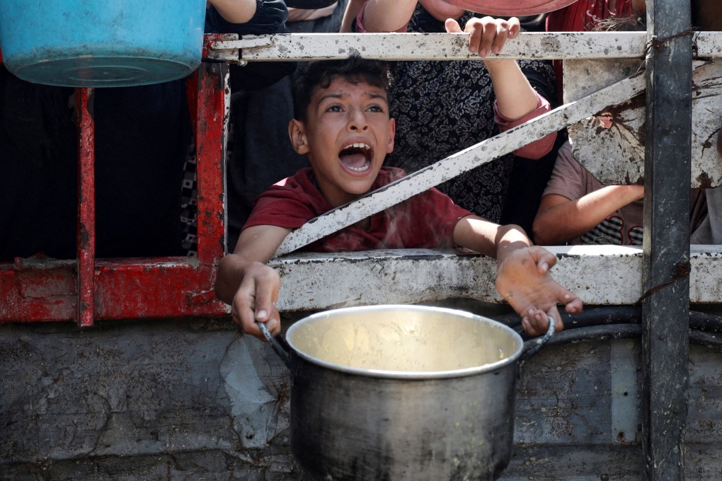 A Palestinian child reacts as he waits to receive food from a charity kitchen amid a hunger crisis in Gaza City on July 28. Photo: Reuters
