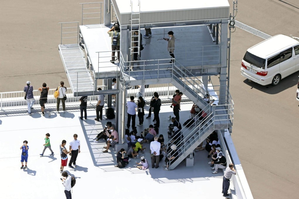 People stand on a rooftop in Mukawa, Hokkaido prefecture, on Wednesday after Japan issued a tsunami warning for the country’s Pacific coast following a powerful earthquake off Russia’s Kamchatka peninsula. Photo: Kyodo