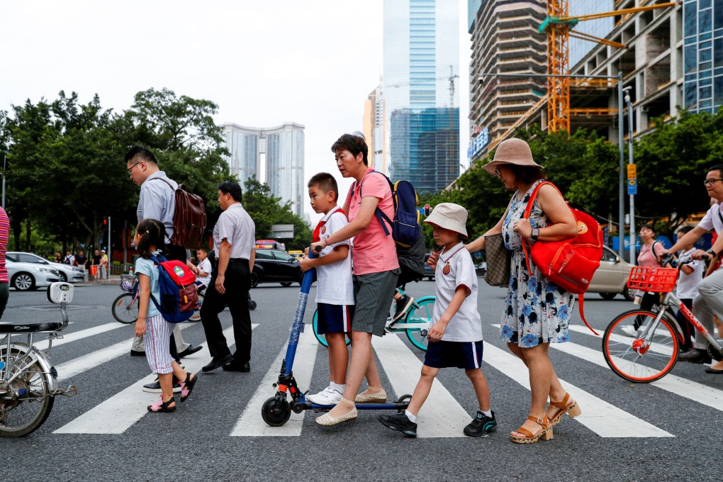 Children and their parents head to school in Guangdong province. The IMF now expects China’s economy to grow by 4.8 per cent this year. Photo: Reuters