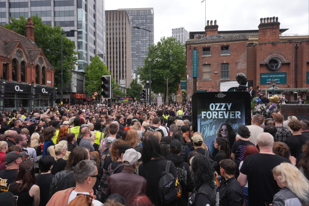 Fans gather near the Black Sabbath Bridge bench on Broad Street in Birmingham, UK for the funeral procession of Black Sabbath frontman Ozzy Osbourne on Wednesday. Photo: PA Wire / dpa