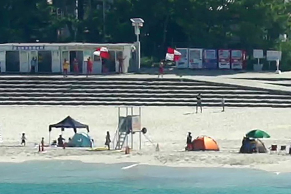Lifeguards wave tsunami flags to alert beachgoers of possible danger in Shirahama in the western Japan prefecture of Wakayama on Wednesday. Photo: Kyodo