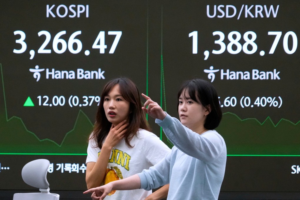 Currency traders work near a screen showing the Korea Composite Stock Price Index and the foreign exchange rate between the US dollar and South Korean won at the foreign exchange dealing room of the Hana Bank headquarters in Seoul on July 31. Photo: AP