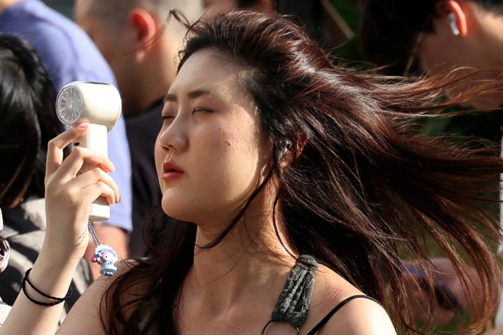A woman uses a portable fan to cool herself during a heatwave in Tokyo, Japan, on July 17. Photo: Reuters