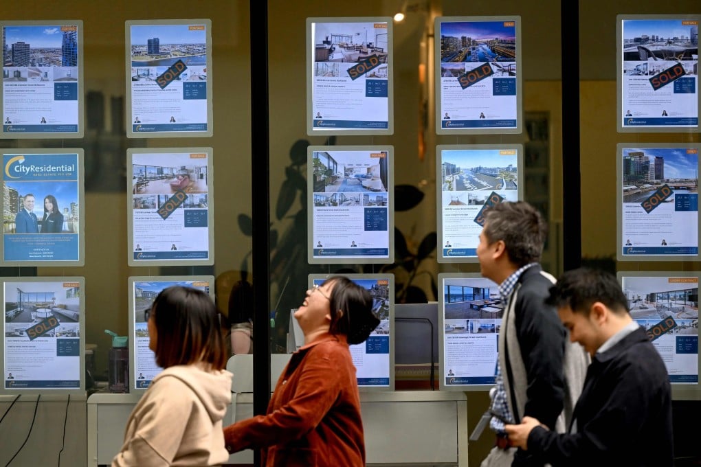 People walk past a real estate agent’s window in Melbourne. Australia was one of the top cross-border real estate investment destinations in the second quarter. Photo: AFP