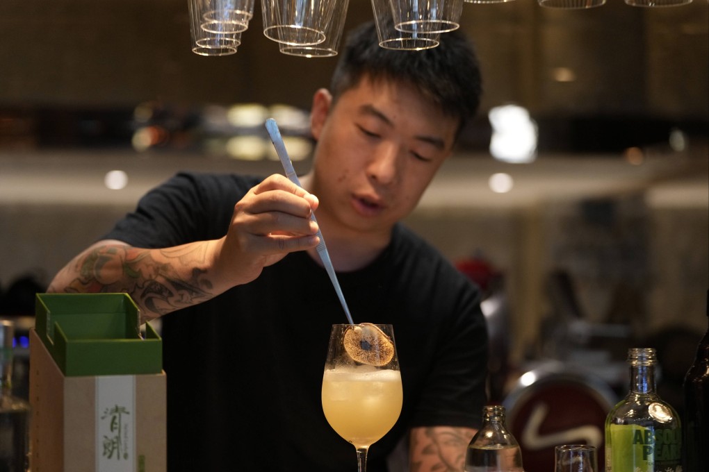 Bartender Allen Zhang places a slice of dried pear on a cocktail named “Beijing Beijing” made with the fiery Chinese baijiu spirit at a bar in Beijing, China, on June 13, 2025. The popular Chinese spirit baijiu is getting rebranded to improve lagging sales. Photo: AP
