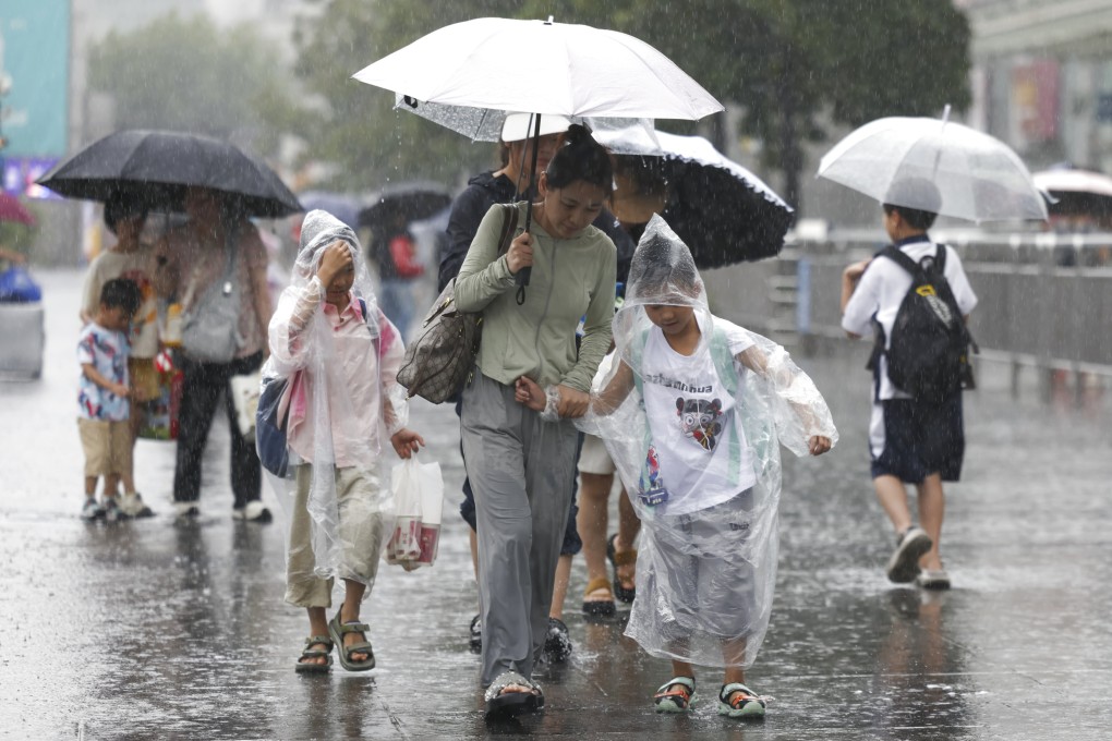 Travellers walk in the rain near Shanghai Railway Station in east China last month during the eighth typhoon of this year. Picture: Xinhua