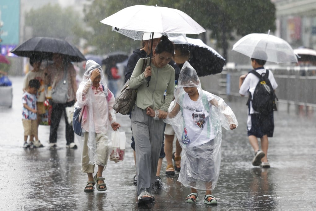 Travellers walk in the rain near Shanghai Railway Station in east China last month during the eighth typhoon of this year. Picture: Xinhua