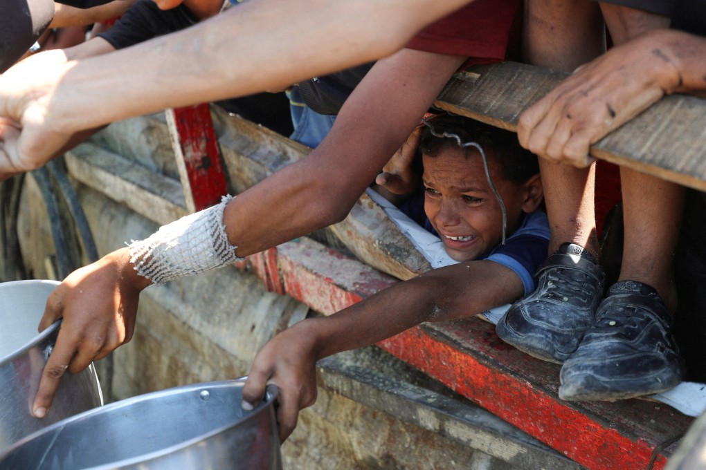 A child in Gaza waits to receive food from a charity kitchen on Saturday. Photo: Reuters