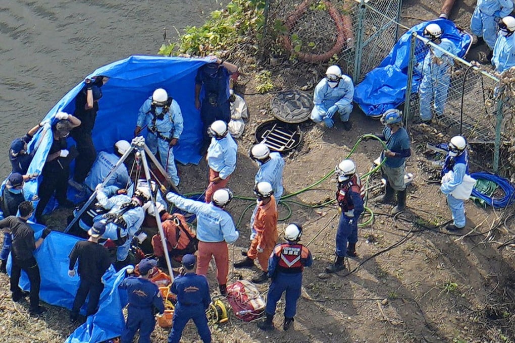 Rescuers look for the stricken workers who fell into a manhole in Gyoda, Saitama prefecture on Saturday. Photo: Kyodo