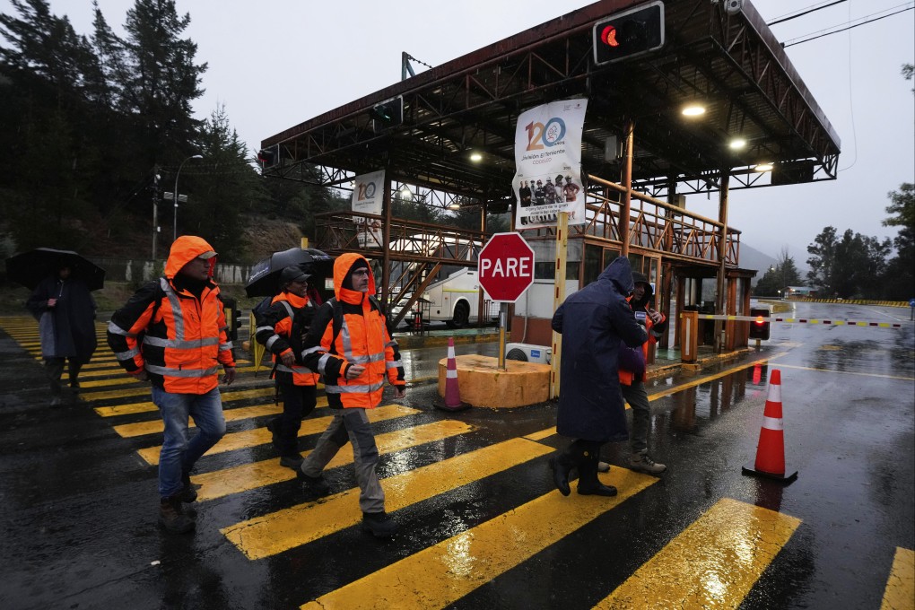 Workers walk at the entrance of the Codelco-operated El Teniente copper mine in Chile, where a collapse killed one worker and trapped five others underground. Photo: AP