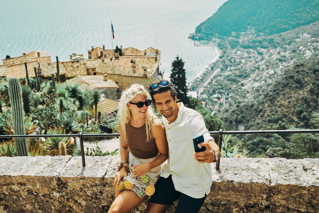 Holidaymakers take a selfie in the historic village of Èze in the south of France. Discerning luxury travellers are avoiding the tourist traps and influencer hangouts for stealth holidays in less-visited locations like Èze. Photo: Shutterstock
