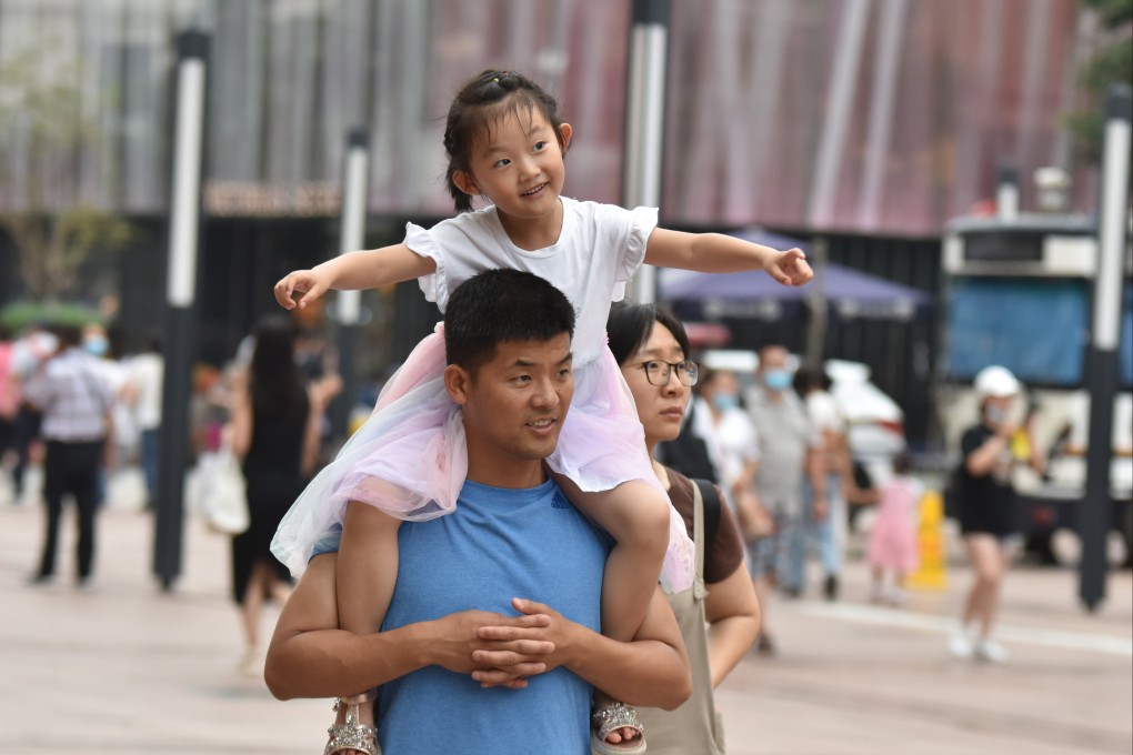 A father carries his daughter on his shoulders on Wangfujing Commercial Street in Beijing, July 21, 2021. Photo: SOPA Images/LightRocket via Getty Images