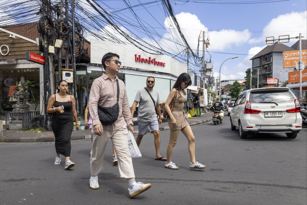 Tourists walk at a shopping area in Seminyak, Bali, Indonesia, on August 1. Bali officials and residents warn that unchecked mass tourism and lax enforcement are creating fertile ground for organised syndicates. Photo: EPA