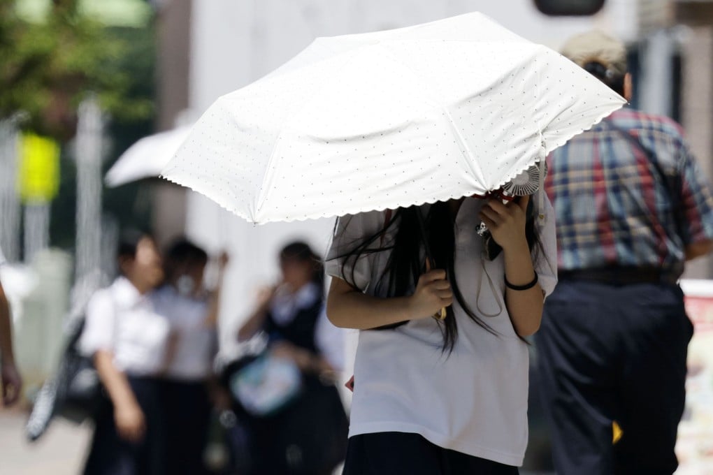 People walk under the scorching sun in Kumagaya, Japan’s Saitama prefecture, on Tuesday. Photo: Kyodo