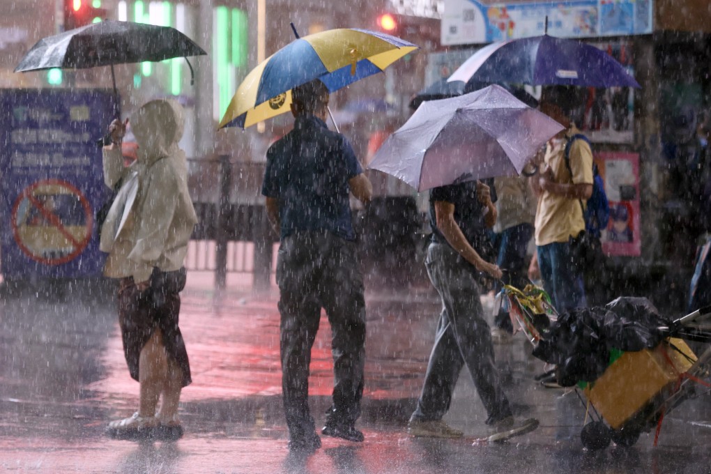 People brave the rain amid a black rainstorm warning on Tuesday. Photo: Jonathan Wong