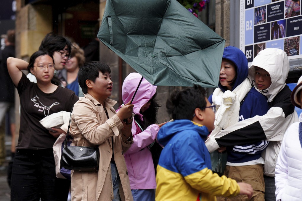 Tourists battle against the wind as they walk along the Royal Mile in Edinburgh, Scotland on Monday amid Storm Floris. Photo: PA via AP