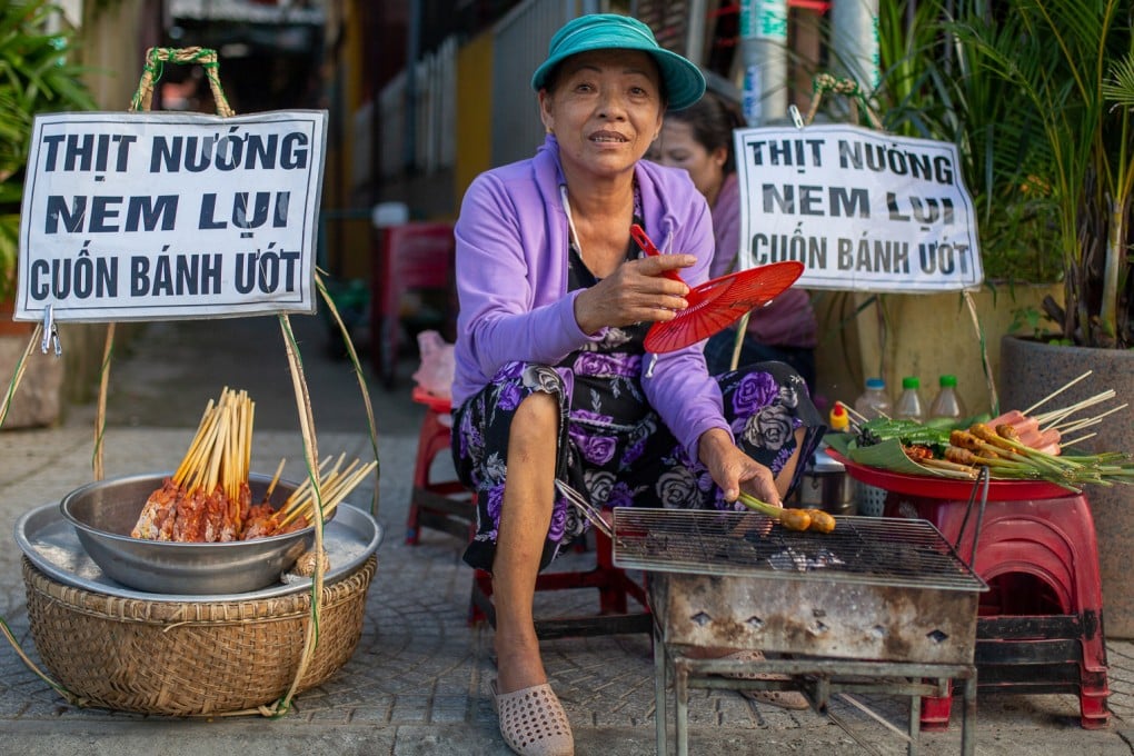 A street seller grills pork skewers beside a river walkway in Hoi An. African swine fever threatens to disrupt pork supply in Vietnam. Photo: Getty Images