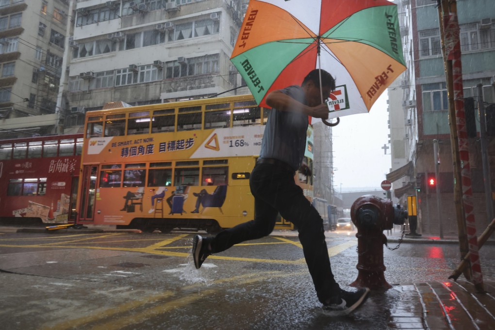 Pedestrians in Sai Ying Pun brave the rain on Tuesday. Photo: Karma Lo