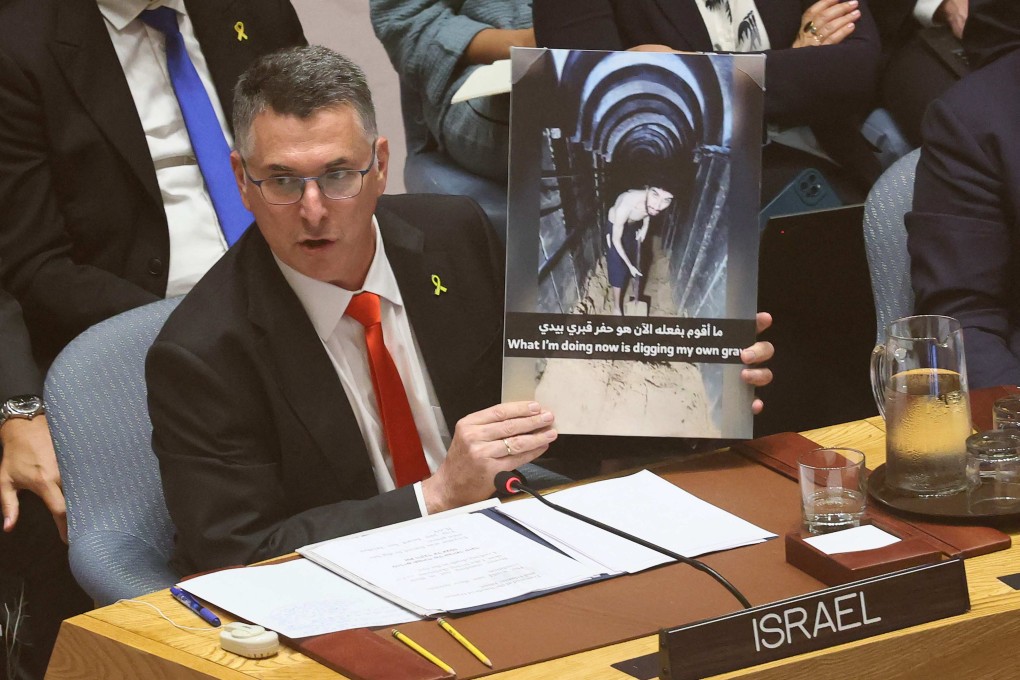 Israeli Foreign Minister Gideon Saar holds up an image of Israeli captive Evyatar David. Photo: AFP