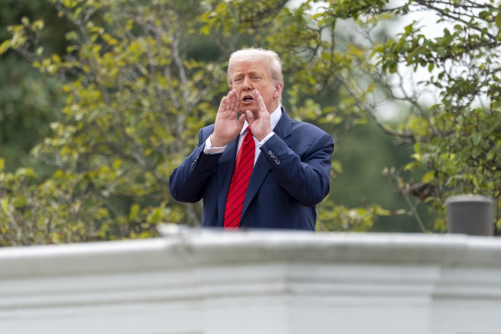 President Donald Trump shouts to reporters as he surveys the grounds from the roof above the Colonnade that goes to the West Wing of the White House, Tuesday, Aug. 5, 2025, in Washington. (AP Photo/Alex Brandon)