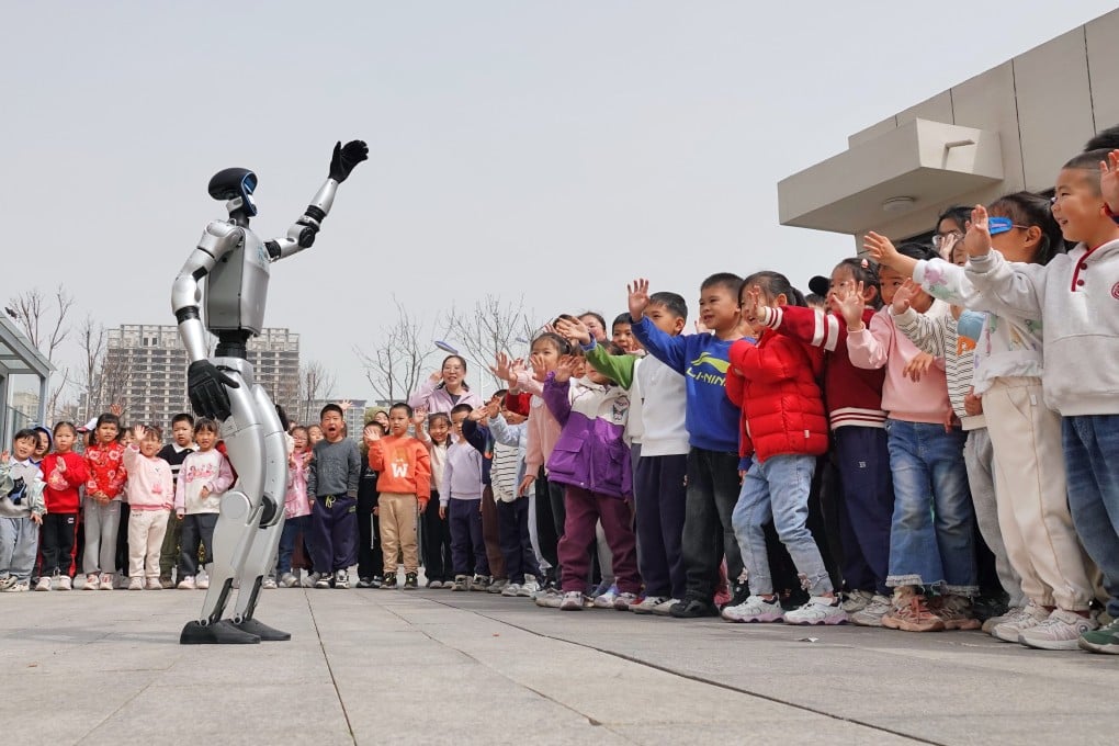 A humanoid robot waves to children at the Second Experimental Kindergarten in the Yantai High-tech Zone, in eastern China’s Shandong province, in March. Photo: Getty Images