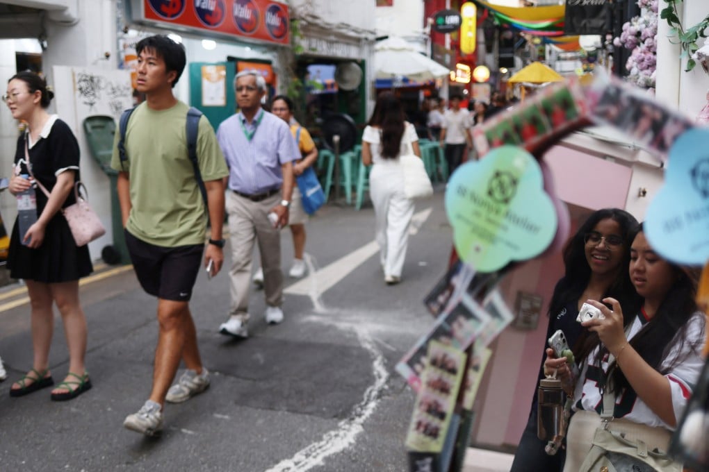 Young people take photos along a shopping street in Kampong Glam district in Singapore on June 11. Photo: Reuters