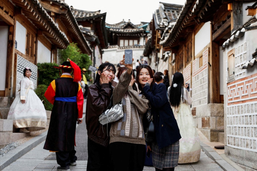 Tourists take selfies at Bukchon Hanok Village in Seoul in October. Starting next month, members of Chinese tour groups will be allowed to enter South Korea visa-free until next June. Photo: Reuters