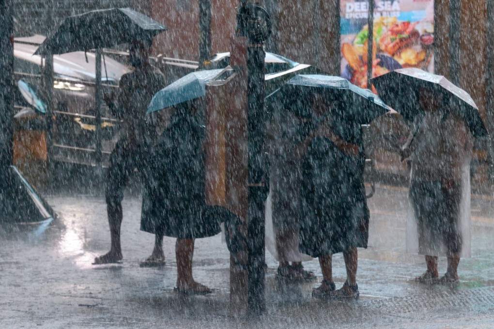 People brave the rain during a black rainstorm warning in Central on August 5. Photo: Jonathan Wong