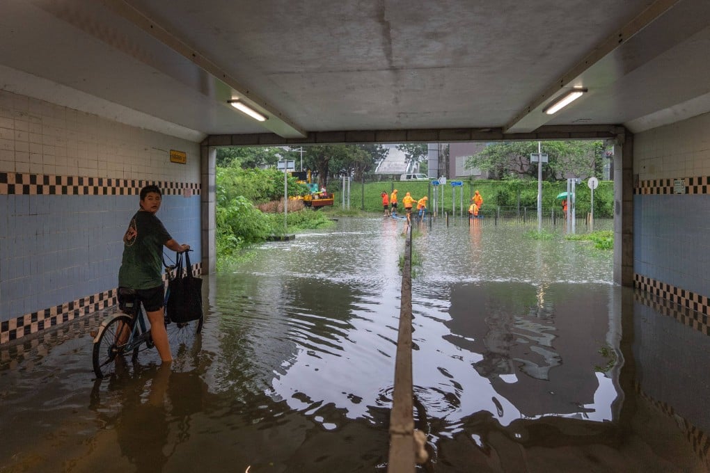 A cyclist moves through a flooded pedestrian tunnel in Tseung Kwan O district on August 5. Parts of Hong Kong were brought to a standstill by flooding caused by heavy rains on August 5, after the highest-tier rainstorm warning was issued for the fourth time in eight days. Photo: AFP