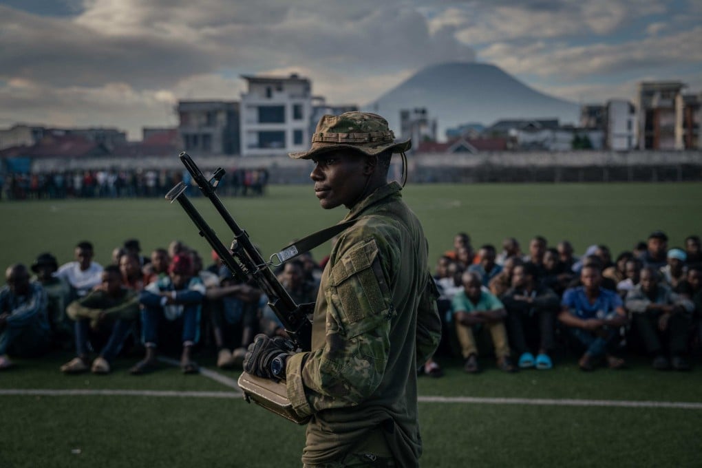 An M23 soldier watches over a group of around one hundred Democratic Forces for the Liberation of Rwanda (FDLR), Wazalendo and Armed Forces of the Democratic Republic of the Congo (FARDC) fighters, at the Stade de l’Unité, in Goma, DR Congo, on May 10. Photo: AFP