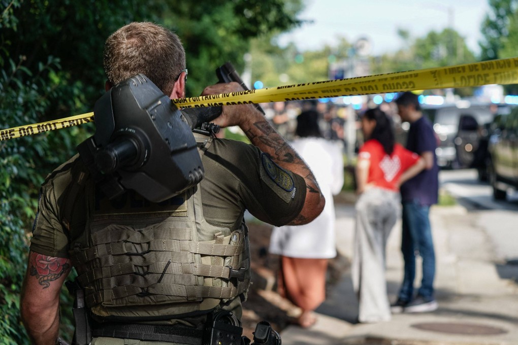 A law enforcement officer walks under police line tape near the scene of an active shooter incident in Atlanta, Georgia, on Friday. Photo: AFP