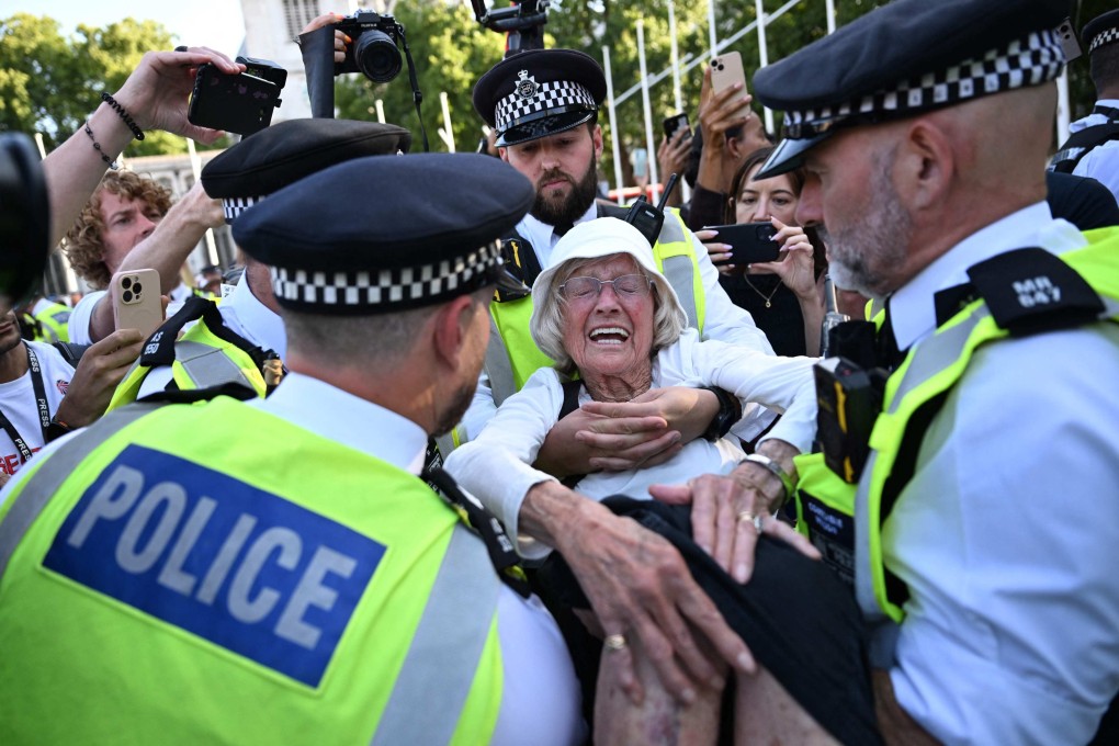 Police officers arrest an 89-year-old protester in London on Saturday. Photo: AFP