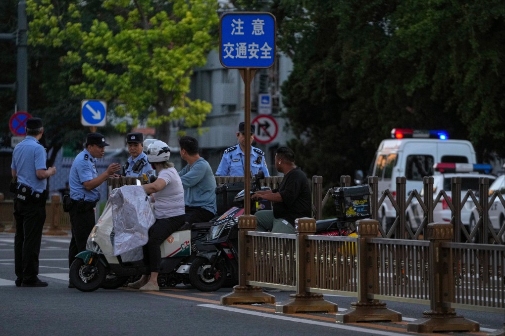 Police officers talk to motorists at a barricaded road near Changan Avenue in Beijing on Saturday, with preparations under way for a military parade in September. Photo: AP