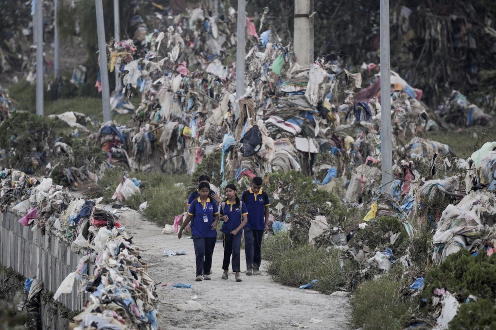 Youngsters walk past plastic waste after flood waters recede from the banks of a river in Kathmandu, Nepal, last year. Photo: Reuters
