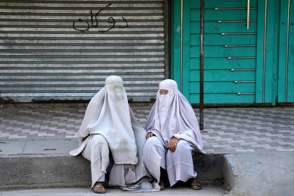 Afghan burqa-clad women sit on a street in Kandahar in July. Photo: AFP