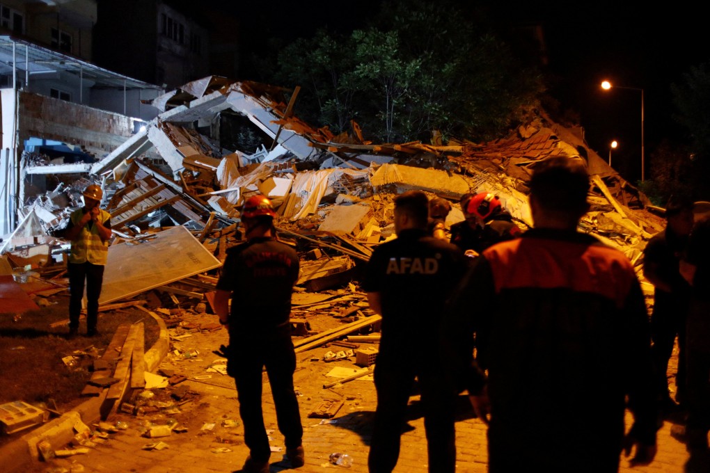 Search and rescue teams next to a collapsed building in Sindirgi, Turkey. Photo: Reuters