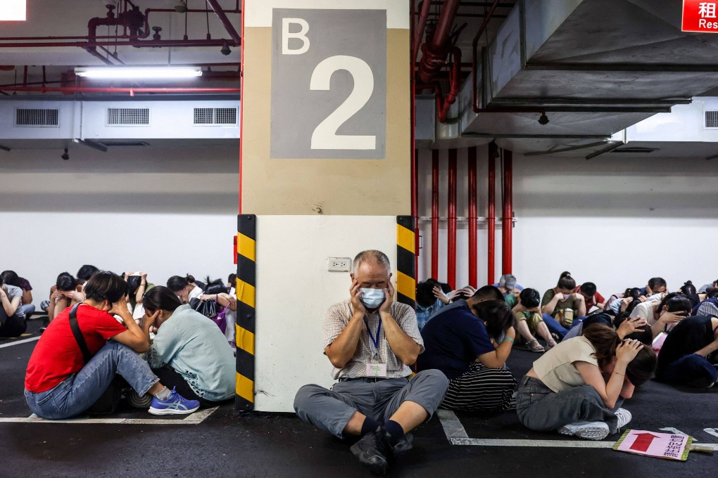 People take shelter during an air raid drill coinciding with the Kan Huang military exercises in Taipei on July 17. The annual civilian drill is held in cities across Taiwan, alongside military training, to prepare the self-governed island for a potential PLA attack. Photo: AFP