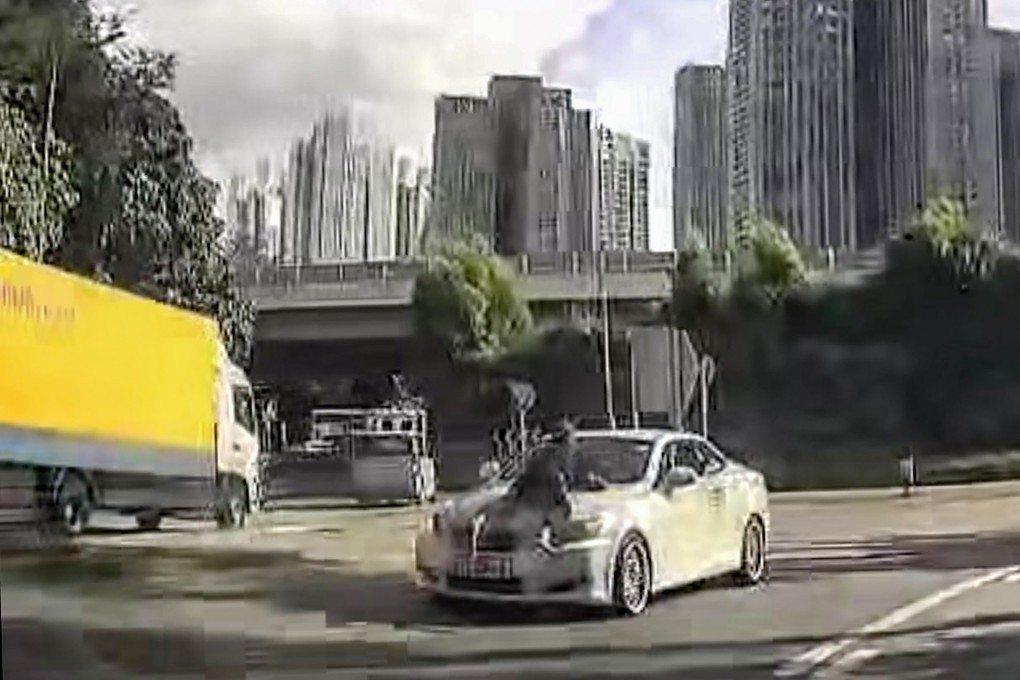 A 37-second clip shows a man clinging to a car on a busy road. Photo: Facebook/Lam Ng