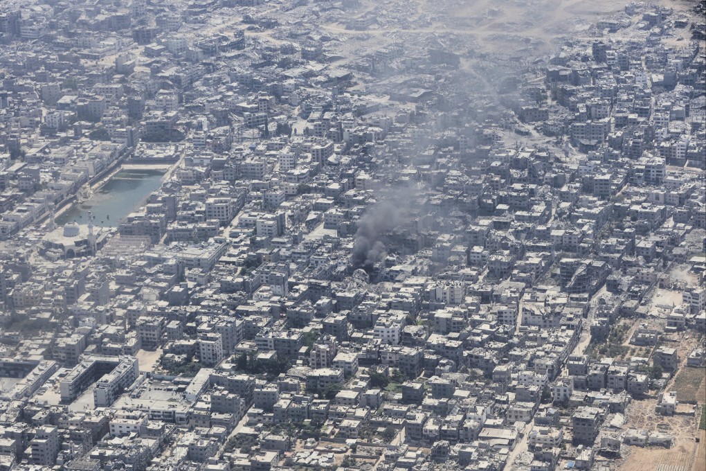 Smoke rises from Gaza City as seen seen from a Jordanian Air Force C-130 plane during an airdrop of humanitarian aid for Palestinians. Photo: AP