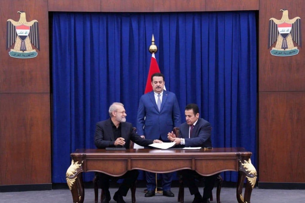 Iraqi Prime Minister Mohammed Shia al-Sudani looks on as Iraq’s National Security Adviser Qasim al-Araji and Ali Larijani, secretary of Iran’s Supreme National Security Council, sign documents in Baghdad, Iraq on Monday. Photo: Iraqi Prime Minister’s Media Office / Handout via Reuters