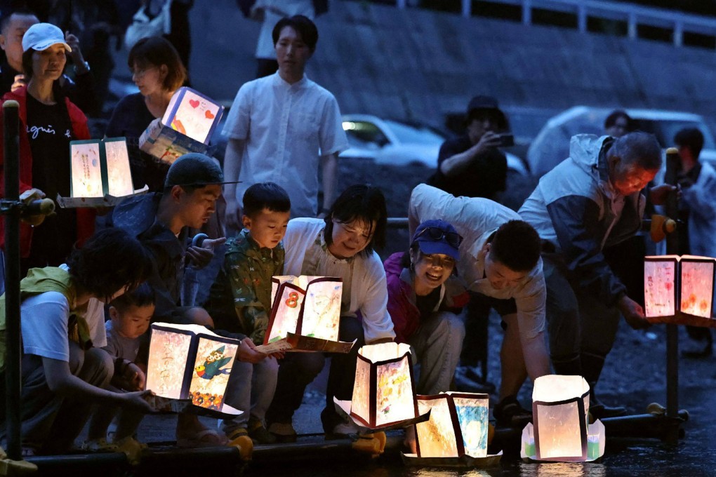 People release lanterns on Monday ahead of the 40th anniversary of the Japan Airlines Flight 123 crash on a river that flows at the foot of Mount Osutaka. Photo: Jiji Press/AFP