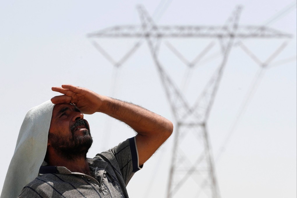 An Iraqi man stands under an electricity transmission tower. Iraq’s 46 million people face rising temperatures, chronic water shortages and year-on-year droughts, in a country intensely impacted by the effects of climate change. Photo: AFP