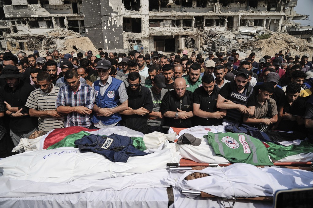 Palestinians pray over the bodies of journalists killed in an Israeli airstrike on August 11. Photo: AP