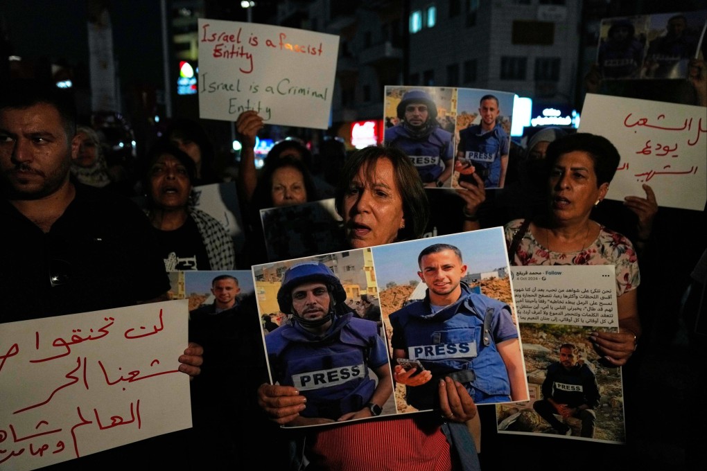 Protesters carry posters with pictures of Palestinian journalists Anas al-Sharif (right) and Mohammed Qreiqeh in the West Bank city of Ramallah on August 11. Photo: AP