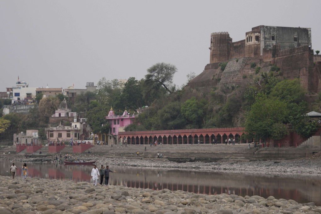 People walk along dry parts of the Chenab River after the water was halted by a dam at Akhnoor, on the outskirts of Jammu, India, on May 5. Photo: AP