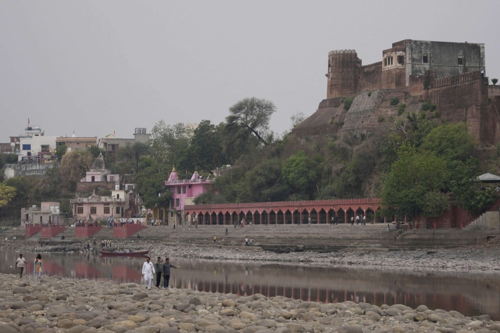 People walk along dry parts of the Chenab River after the water was halted by a dam at Akhnoor, on the outskirts of Jammu, India, on May 5. Photo: AP