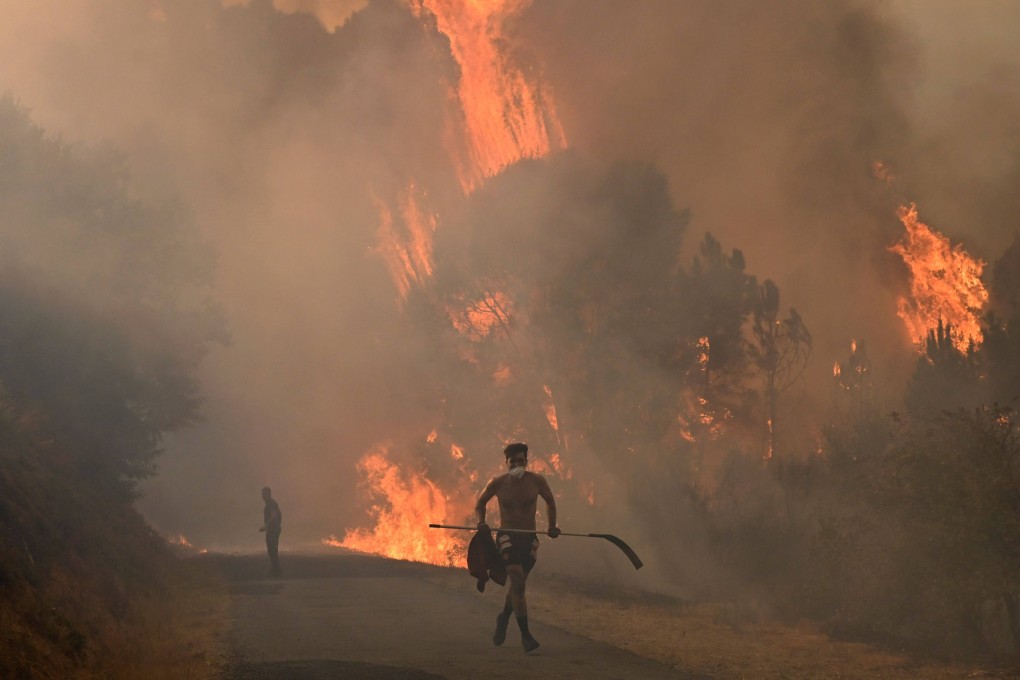 A man runs out of the flames during a wildfire near the village of Larouco in northwestern Spain on Wednesday. Photo: AFP