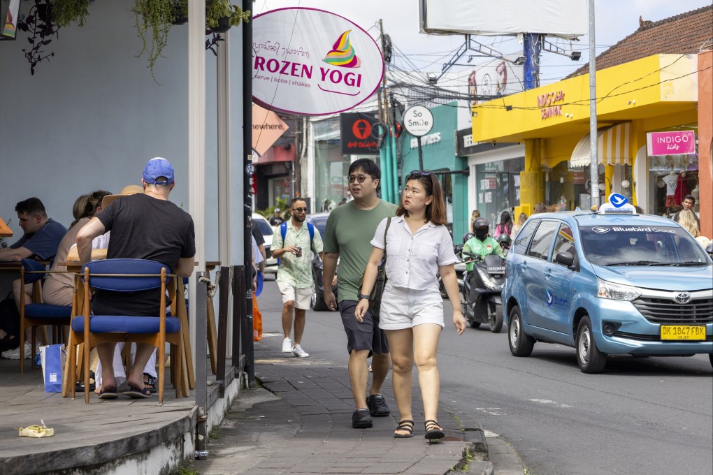 Tourists walk at a shopping area in Seminyak, Bali, Indonesia, on August 1. Patrols are being carried out across the island until August 31 to keep lawbreaking foreigners in check. Photo: EPA