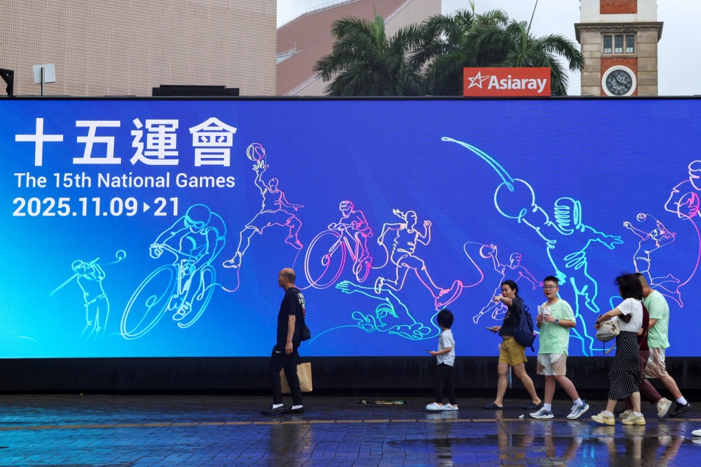 Residents walk past a large advertisement near the Tsim Sha Tsui Ferry Pier promoting the 15th National Games. Photo: Jelly Tse