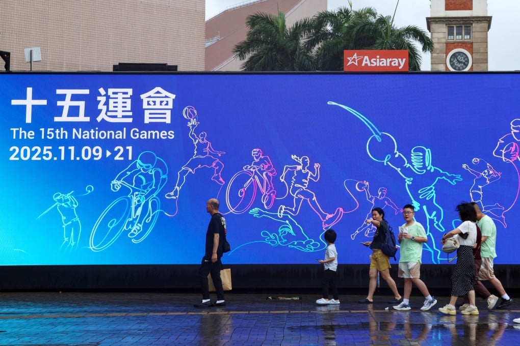 Residents walk past a large advertisement near the Tsim Sha Tsui Ferry Pier promoting the 15th National Games. Photo: Jelly Tse